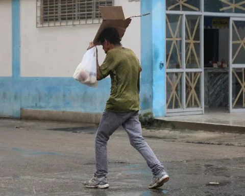 Un hombre se guarece de la lluvia en La Habana