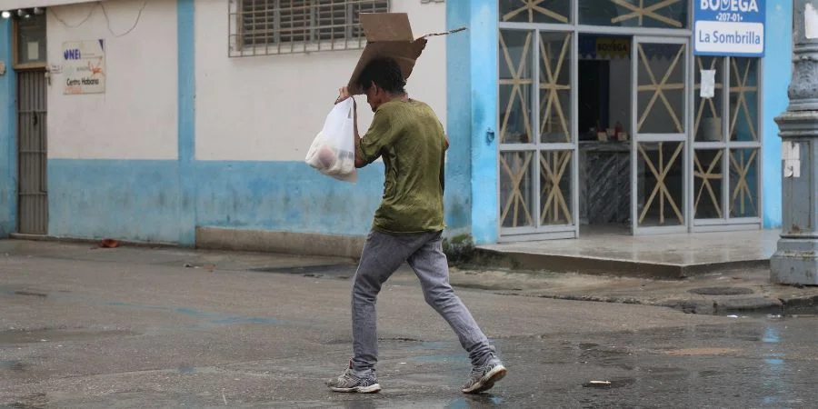 Un hombre se guarece de la lluvia en La Habana